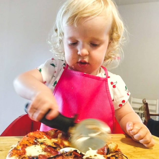Child cutting pizza